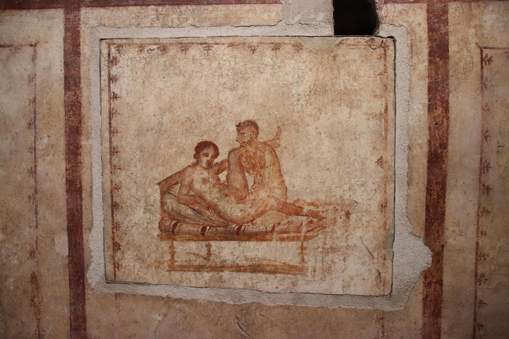 VI.15.1 Pompeii. October 2023. 
Erotic painting on east wall in bedroom (x’), used either by servants or as a private brothel? Photo courtesy of Klaus Heese.