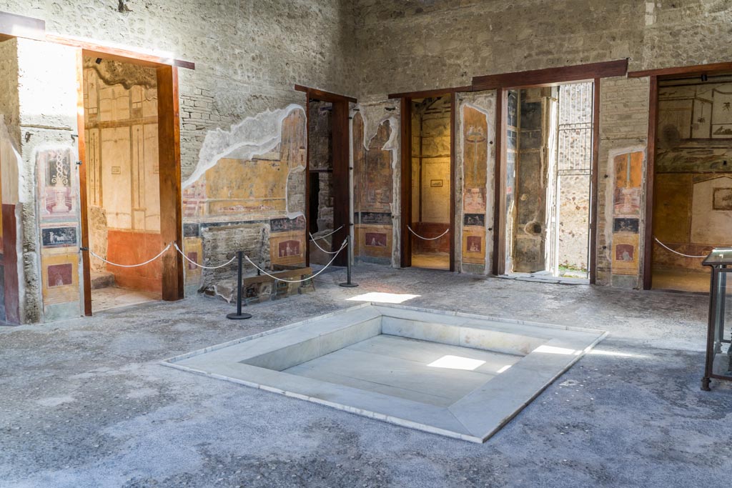 VI.15.1 Pompeii. March 2023. Looking north-east across atrium. 
The doorway to the services area, is centre left, and doorway to cubiculum k in north-east corner of atrium, is centre right.
Photo courtesy of Johannes Eber.