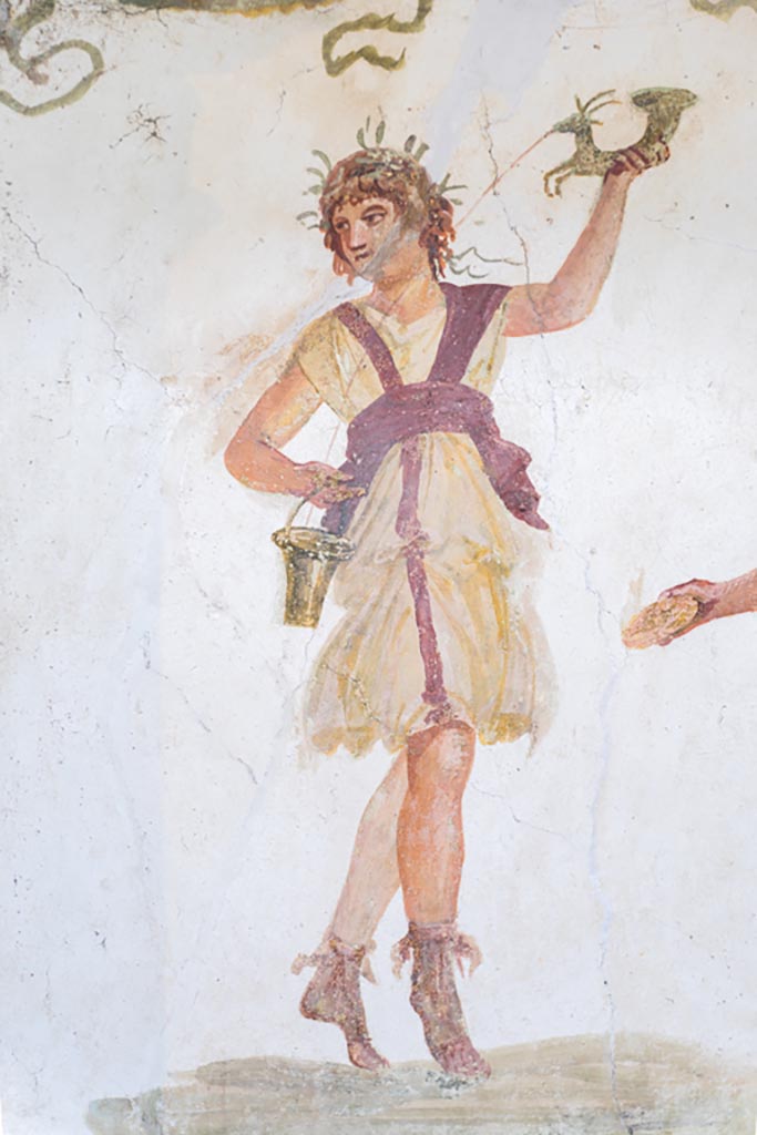 VI.15.1 Pompeii. March 2023.
Detail of wreathed Lar holding rhyton and situla, from south end of lararium.
Photo courtesy of Johannes Eber.