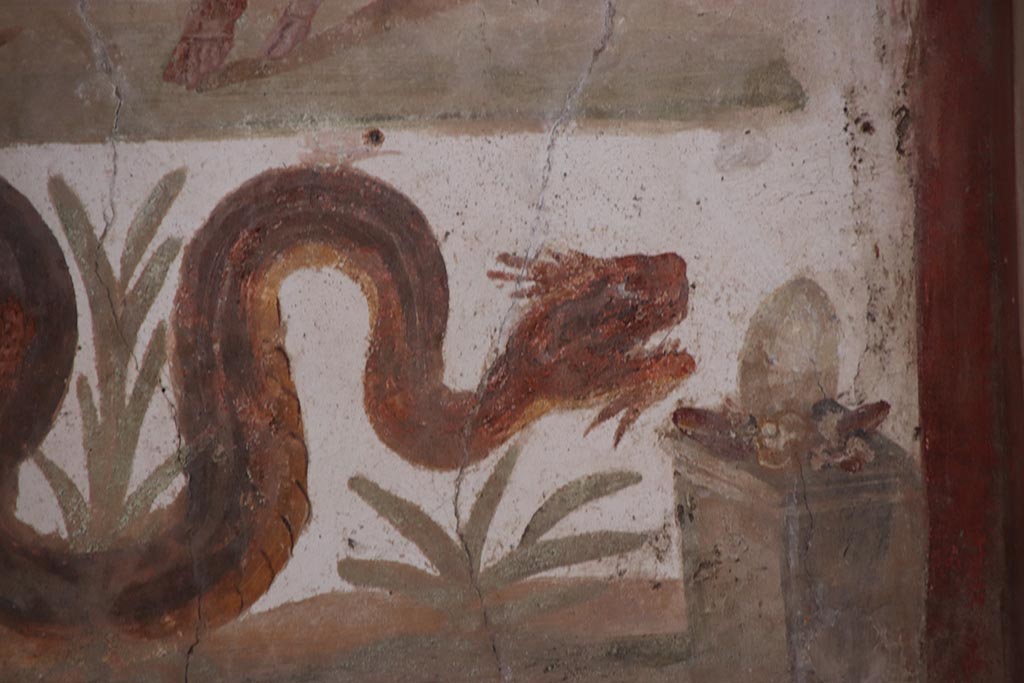 VI.15.1 Pompeii. October 2024.
Detail of serpent on lararium painting gliding through plants towards altar. Photo courtesy of Klaus Heese.