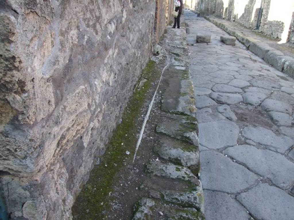 Lead pipe in pavement between VI.15.3 and VI.15.4 on Vicolo dei Vettii. December 2007.
The pipe goes through the wall of VI.15.4.