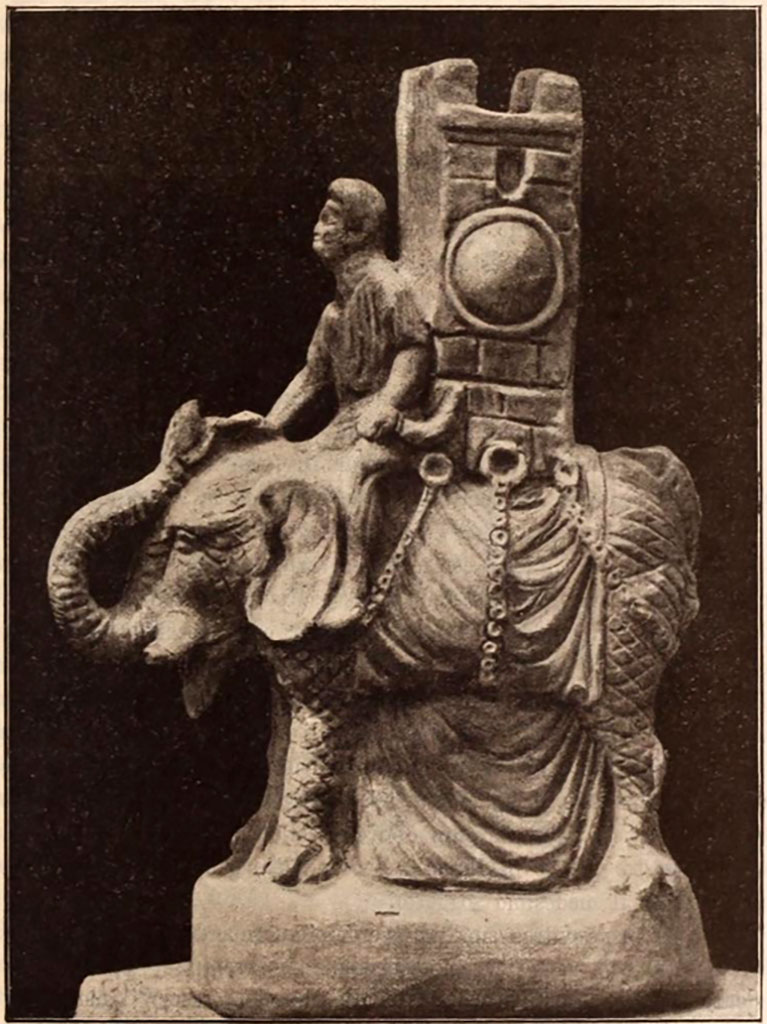 VI.15.5 Pompeii. Clay figurine of an elephant carrying a tower on its back, 0.35m high incl. base.
The figurine served as a vessel for liquid. 
The liquid was put in through the top of the tower, which was open.
See Notizie degli Scavi di Antichità, 1897, p.25, fig. 3.
It was found in October 1895 in or near the garden niche, together with a group of other objects.
See Notizie degli Scavi di Antichità, 1895, p.438.
According to Jashemski, this was also a jug, and was now in the Naples Archaeological Museum, inventory number 124845, Ruesch 442. 
See Jashemski, W. F., 1993. The Gardens of Pompeii, Volume II: Appendices. New York: Caratzas. (p.155)