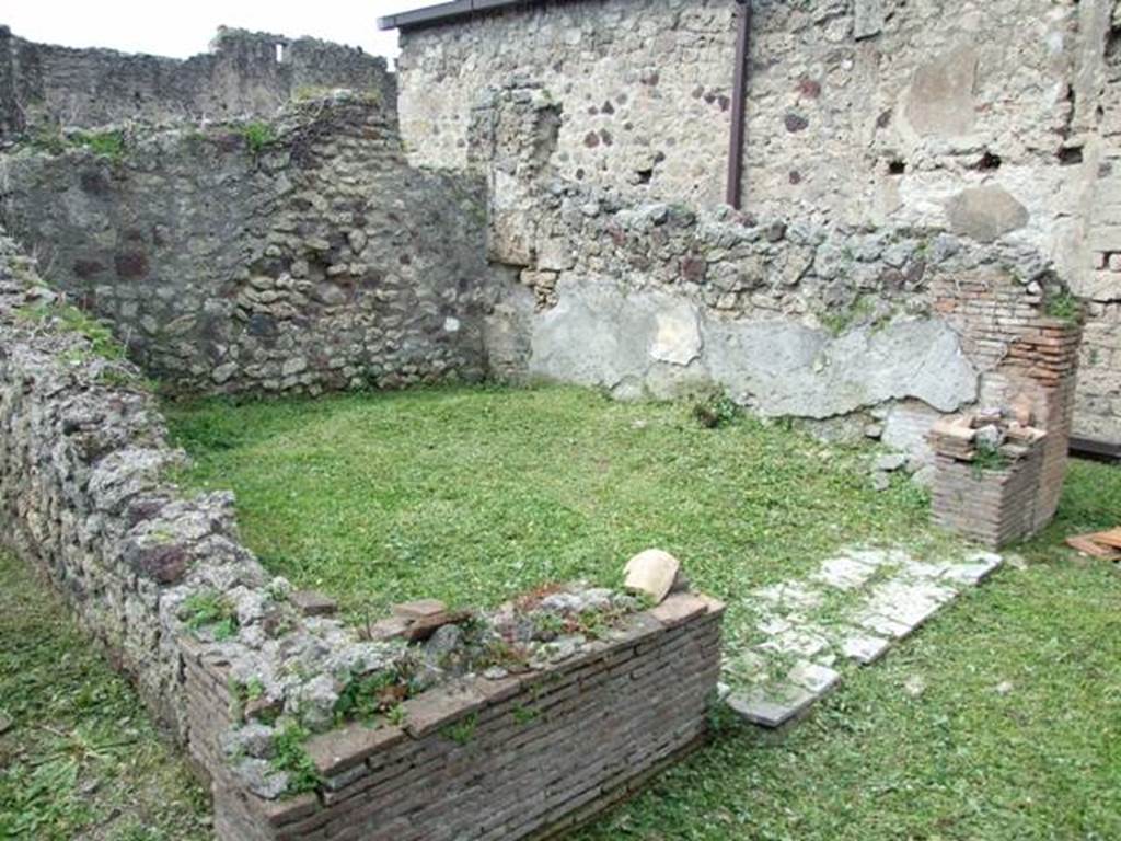 VI.15.6 Pompeii. March 2009. Room 5, tablinum.  Looking north-west. According to NdS, originally the rear of the tablinum would have had a wide doorway, the same as that in the front, but this was walled up, keeping in place the wooden doorjambs of the ancient doorway, which having been destroyed, left an empty gap on both sides of the walling.
At the other end, the threshold of the room was a slab of bardiglio marble and the floor was signinum. In the middle of the floor was a coarse circular ornamental design which indicated the place of the table. It was therefore used as a triclinium. The remains of the decoration showed that in the middle of each wall, there would have been a yellow panel between two black side panels, above a dado with a black background. See Notizie degli Scavi, January 1897, (p.30-31)