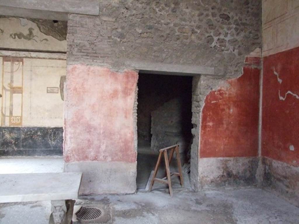 VI.15.8 Pompeii. December 2007.  West wall of the atrium and doorway to kitchen area, on right. At the foot of the dividing pillar between these two rooms, in the floor of the atrium, was the mouth of the cistern.