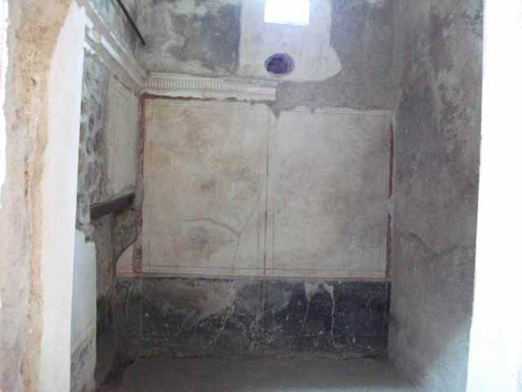 VI.15.8 Pompeii. May 2010. Looking through doorway in cubiculum on south side of entrance corridor.
Looking towards east wall of cubiculum with window onto Vicolo dei Vettii.
According to NdS, this room had been covered by a barrel-vaulted ceiling and had a recess for a bed.
The walls were decorated with a white background and had a stucco cornice which ran around the walls at a height of approximately 2m from the floor.
See Notizie degli Scavi di Antichità, January 1897, (p.34).