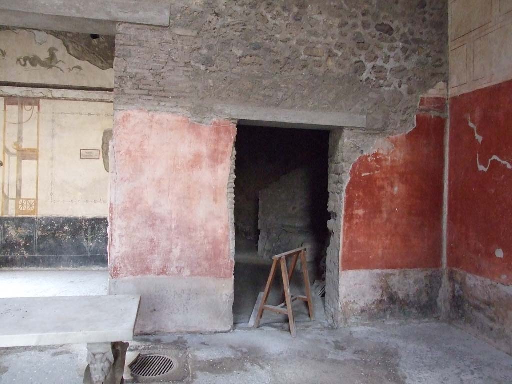 VI.15.8 Pompeii. December 2007. West wall of the atrium and doorway to kitchen area, on right.
At the foot of the dividing pillar between these two rooms, in the floor of the atrium, was the mouth of the cistern.