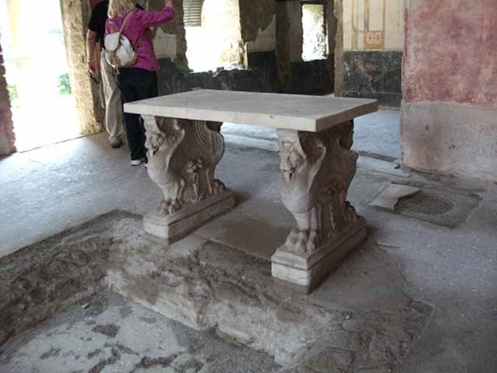VI.15.8 Pompeii. May 2010. Marble table in atrium, supported by two legs decorated with  flying animals with lion’s paws.