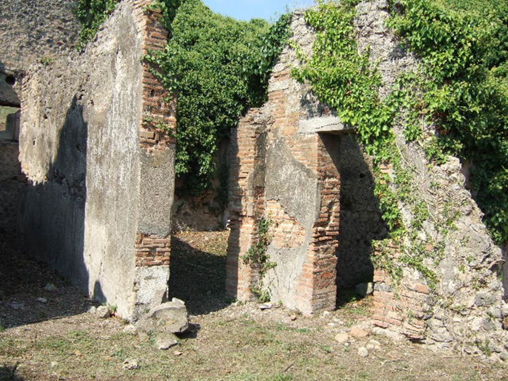 VI.15.20 Pompeii. September 2005. Looking north-east from atrium towards doorways to corridor to kitchen, left, and oecus, centre. According to Hobson, Reg. VI had two upper storey latrines that still had visible signs of the latrine above the ground floor level, these were in VI.15.20 and VI.15.22.  See Hobson, B., 2009. Latrinae et foricae: Toilets in the Roman World. London; Duckworth. (p.75)
According to Eschebach, the corridor on the north side of the atrium led to the kitchen and latrine which had a downpipe from the upper floor. See Eschebach, L., 1993. Gebäudeverzeichnis und Stadtplan der antiken Stadt Pompeji. Köln: Böhlau. (p.223)
According to NdS, only the lower part of the walls of the oecus were faced with white plaster, partitioned by black lines. In the south wall was a small niche. See Notizie degli Scavi di Antichità, June 1897, (p.275)
In the room to the north of the tablinum, the doorway on the right of this photo, a pile of lime prepared for work was found, together with some tiles. (p.274)