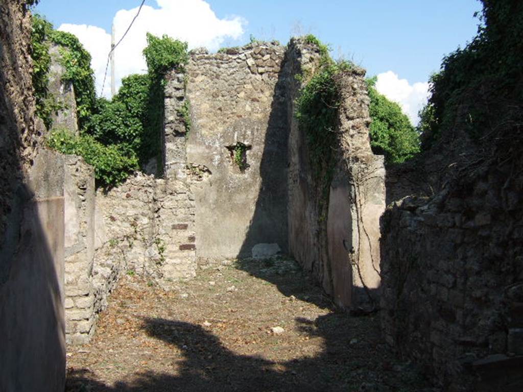 VI.15.22 Pompeii. September 2005. Looking east towards tablinum, with window.  According to NdS, this small house had walls coated with rustic plaster, with a high dado of brick plaster (mattone pesto). On entering the house, on the right, was the kitchen.
On the extreme lower right of the above photo would be the stairs to the upper floor.
The perfectly preserved remains of an upstairs latrine were discovered on the upper floor.
The doorway in the wall on the right leads to a room where a human skeleton was found on 26th June 1897. Opposite the doorway, on the left, was a small garden. The doorway on the left leads into a room, the triclinium, with a window onto the garden. See Notizie degli Scavi, June 1897, (p.272-3)
Another human skeleton was reportedly found in a room on the south side of the atrium on 17th June 1899. See Notizie degli Scavi, June 1899, (p.235)
According to Hobson, there were two upper storey latrines discovered in Reg. VI, one in VI.15.20, the other here in VI.15.22. See Hobson, B., 2009. Latrinae et foricae: Toilets in the Roman World. London; Duckworth. (p.75)