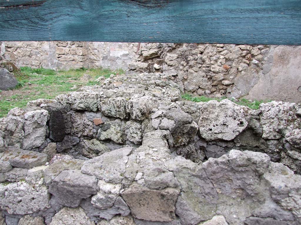 VI.16.2 Pompeii. December 2007. 
Looking north across two-sided podium or counter, showing holes for two of the three urns, in the front part.
According to Sogliano, the receding part of the counter was very damaged when found.
The outside surface of the rear part was covered with stucco painted in red; the upper part had fragments of slabs of marble embedded into it.
See Notizie degli Scavi di Antichità, 1906, (p.345).