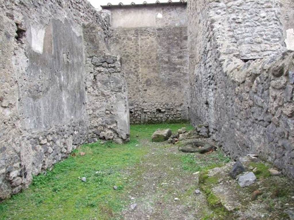 VI.16.5 Pompeii. December 2007. Looking west across shop towards rear room. According to Sogliano in NdS, when first excavated the walls were unadorned.  Leaning against the right of the north wall were the remains of a large masonry feature with two steps before it.
To the right of this same and really in the north-east corner, there seemed to be seen the remains of a fusorium. Towards the other side of the same wall, there was a circular lava cistern mouth, (centre right of photo). See Notizie degli Scav idi Antichità, 1906, (p.350, and plan on p.346).