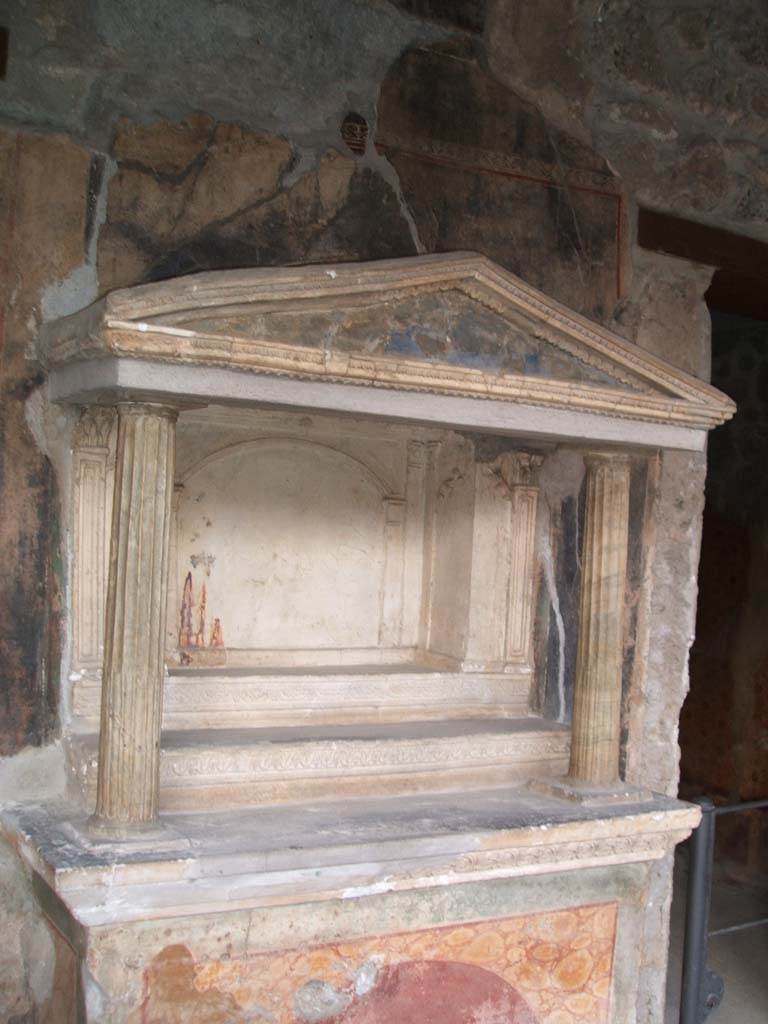 VI.16.7 Pompeii. December 2004. Room F, north portico. Household lararium. 
Two fluted marble columns, with architrave and pediment. 
The rectangular niche has its floor divided into three levels by two high steps (shelves).