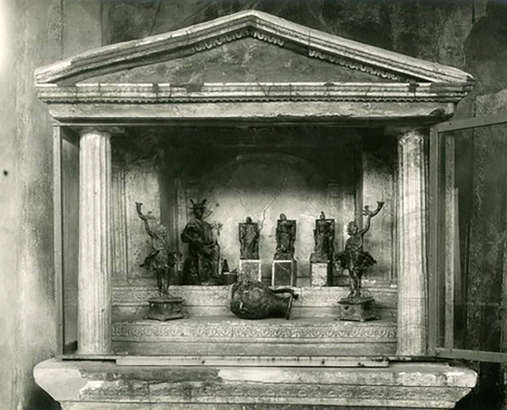 VI.16.7 Pompeii. Statues found in the lararium.  
Seated on the top step are Mercury, Juno, Jupiter and Minerva.  
The two Lares were placed, on either side of the group, but on the lower step.
Also found was a bronze vase in the shape of an oinochoe with a large belly, flat bottom, protruding lip and a handle set laterally to this.
Now in Naples Archaeological Museum. Inventory numbers 133323, 133324, 133325, 133327, 133328 (and 133326?).
See Boyce G. K., 1937. Corpus of the Lararia of Pompeii. Rome: MAAR 14, pp. 57-8, no. 221, and pl.38, 2.
See Notizie degli Scavi di Antichità, 1907, pp. 564-571, fig. 14.