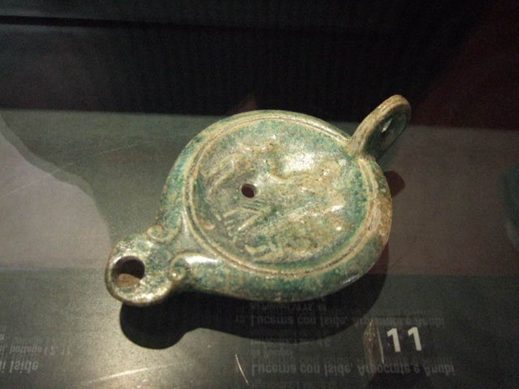 VI.16.7 Pompeii. Found in the corner near the lararium in room F, peristyle.  
Terracotta lamp with images of Isis, Harpocrates and Anubis.  
Now in Naples Archaeological Museum.   See Engelmann, W., 1929.  New Guide to Pompeii: Second Edition.  Engelmann.  (p. 52).