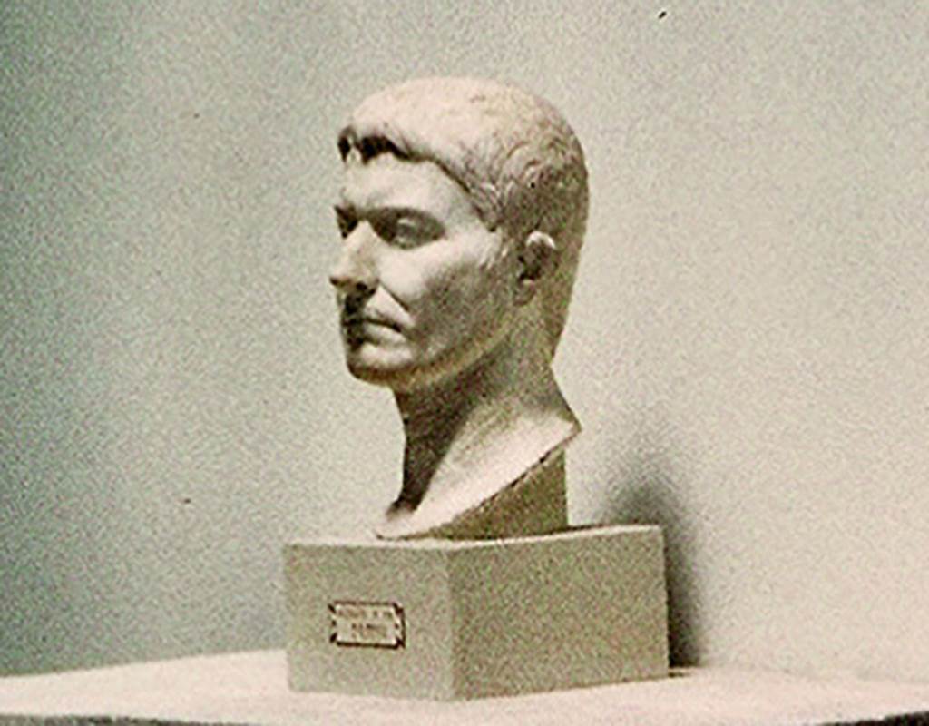 VI.16.7 Pompeii. On display in Antiquarium in August 1965. Portrait bust of an unknown male, still of young age. In the base is an iron pin, indicating that it once stood on a pilaster.
Found in the third gap in the columns of the southern portico, starting from the south-west corner.
According to PPM, the style of the portrait indicates the late-Tiberian era.
SAP inventory number 55514 or 3015. Photo courtesy of Rick Bauer.
See Notizie degli Scavi di Antichità, 1907, p. 593; fig. 41.
See Carratelli, G. P., 1990-2003. Pompei: Pitture e Mosaici: Vol. V.  Roma: Istituto della enciclopedia italiana, p. 746.