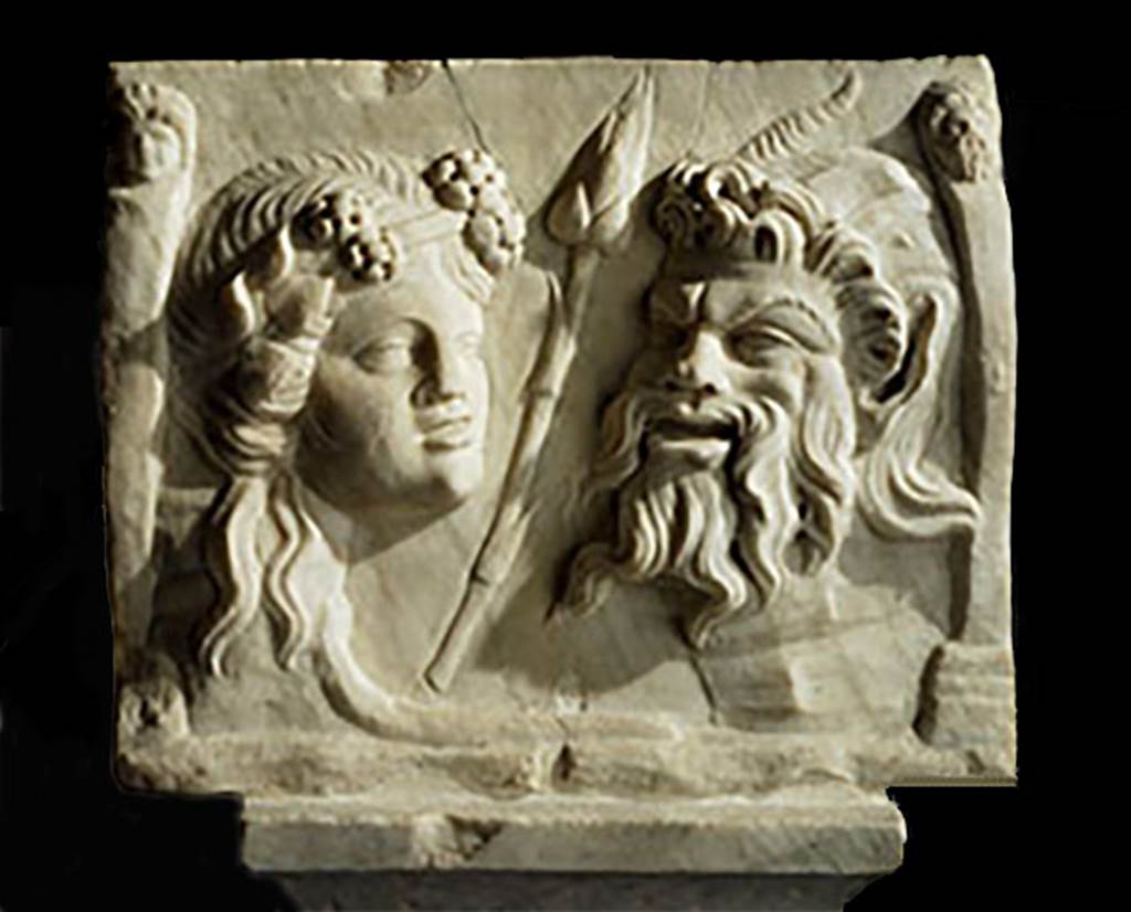 VI.16.7 Pompeii. 
Two heads or masks (recognised as an ivy-wreathed maenad one of the female followers of the god Bacchus, and of the god Pan recognised by his goat horns) on reverse side of rectangular marble relief of satyr and Silenus, from south-east corner of peristyle garden. Found 1904. 
SAP inventory number 20460.
