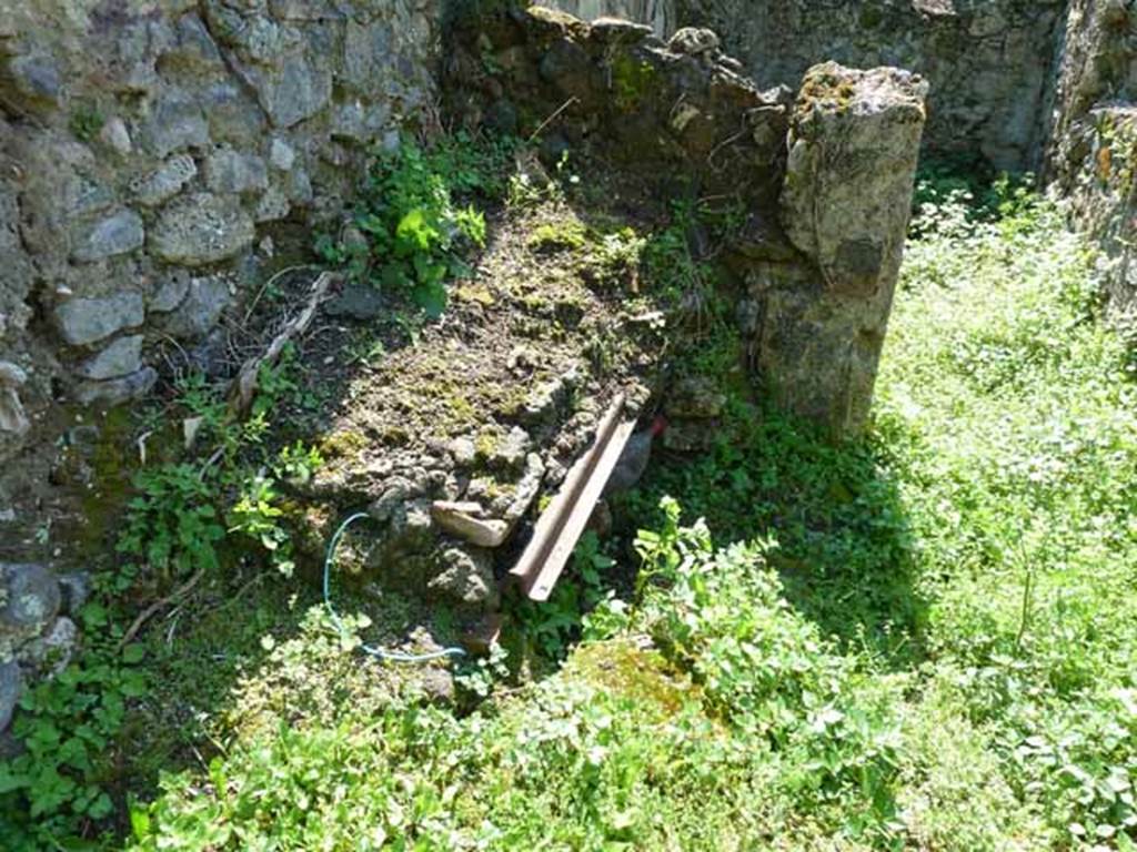VI.16.11 Pompeii. May 2010. Remains of kitchen hearth and doorway to cubiculum.
According to NdS, at the western end of the corridor was a hearth with a masonry stove. 
The hearth, which was empty underneath, had its upper part formed by four tiles.