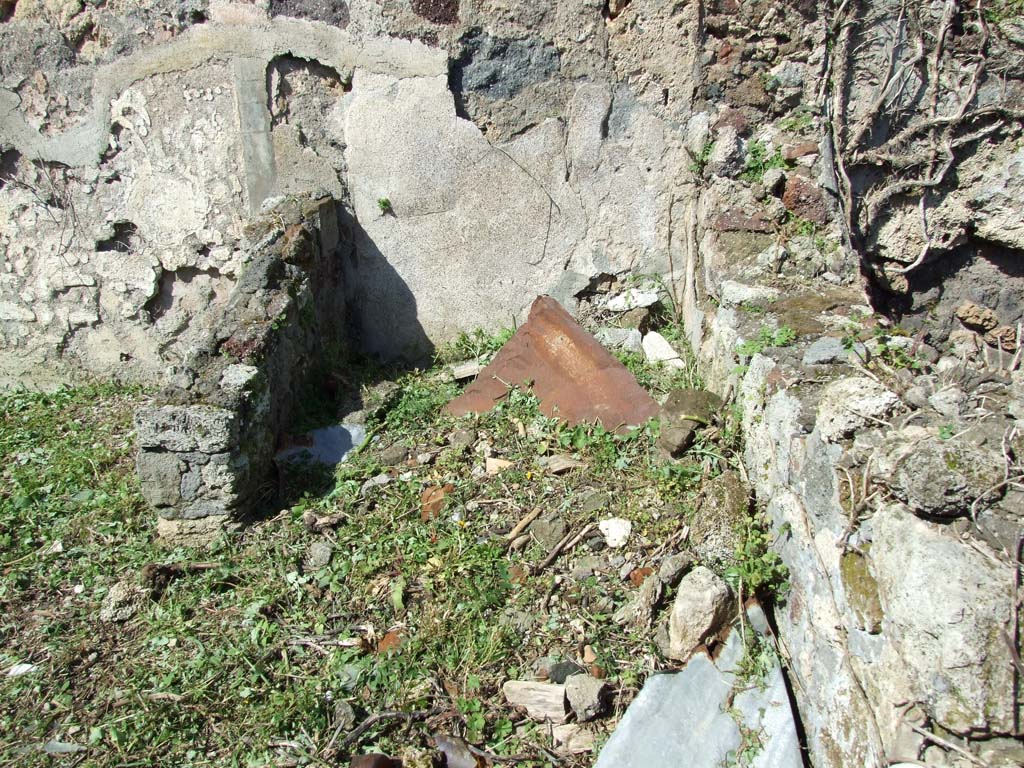 VI.16.12 Pompeii. March 2009. First rear room. North wall, east end with remains of structure.
According to NdS, from the corridor one came into this area, which was probably unroofed.
In the north-east corner of this area, a circular cistern mouth was found, around it was the remains of opus signinum flooring.
The mouth of the cistern was placed between two small walls, the higher one was perpendicular to the north wall, on the left.
The other lower wall was perpendicular to the east wall and would have been in the foreground.