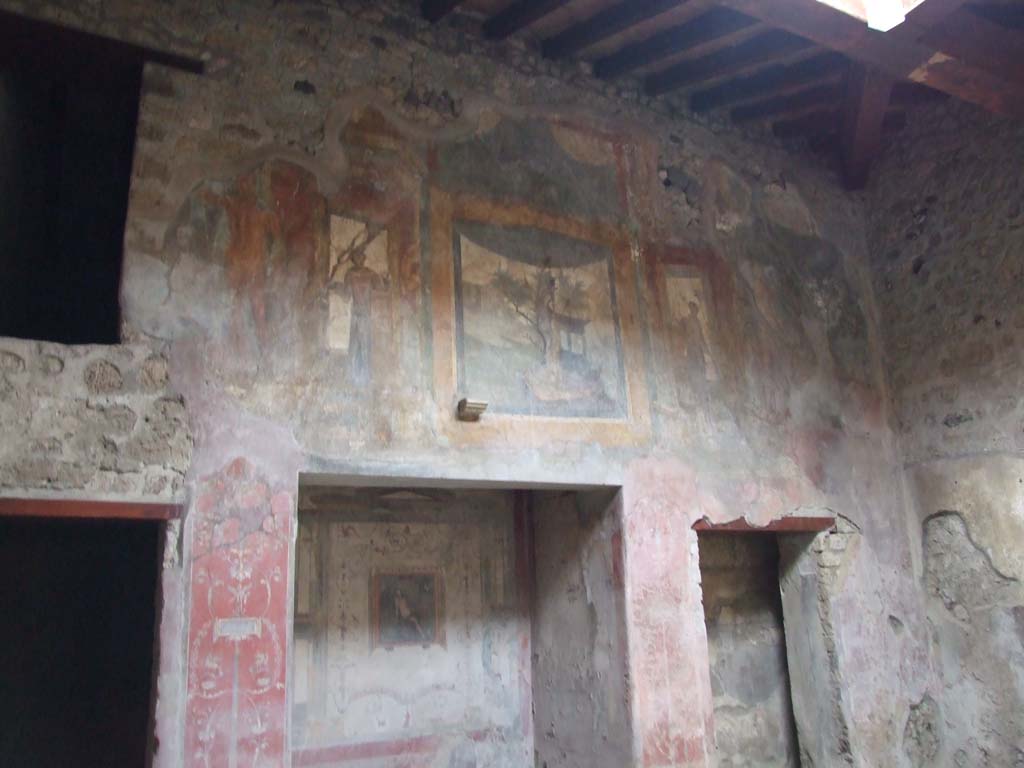 VI.16.15 Pompeii. December 2006. West wall of atrium B, detail of upper wall paintings. 
Architectural painting with blue curtain, sacred landscape and at the extremities, statues of Poseidon and Nike.