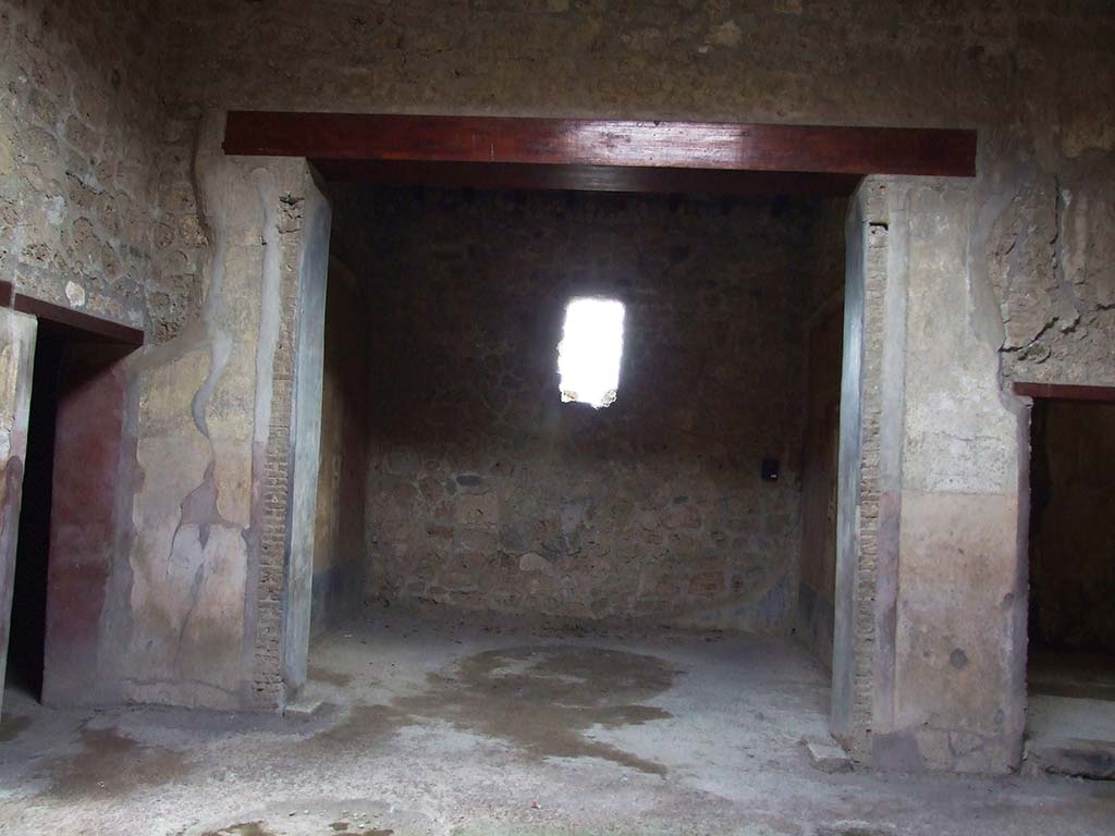 VI.16.15 Pompeii. December 2006. Doorway to room F in centre of south wall of atrium. 
According to NdS, on the south side of the atrium opened room F almost in its entire width.
It had two black background painted jambs, on which were vertical bands of white, yellow and red.
The floor was of rough cocciopesto.
The south wall was entirely destroyed, while the west and east walls were well preserved.
Sogliano thought the room was probably used as a triclinium.