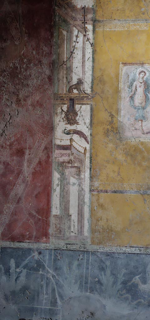 VI.16.15 Pompeii. December 2023.
South end of central painting of west wall of room F. 
Architectural wall painting with panther, mask and peacock.
Photo courtesy of Miriam Colomer.