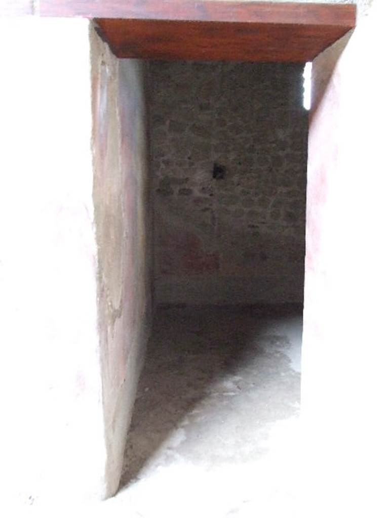 VI.16.15 Pompeii. December 2006. Doorway to room H to south-east of atrium. This room had an entrance threshold of lava with the usual hole for the pivot of one door shutter leaf.
The floor was of cocciopesto and littered with pieces of slabs of marble and very small pieces of marble, arranged in groups of three, each forming a triangle. See Notizie degli Scavi, 1908, (p.82)