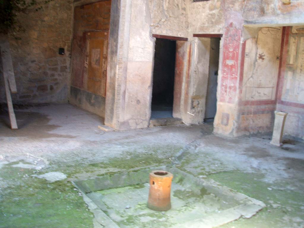 VI.16.15 Pompeii. May 2005. Looking south-west across impluvium in atrium B.
The doorways of rooms G and C are in the corner, with room F to the left and room D to the right.