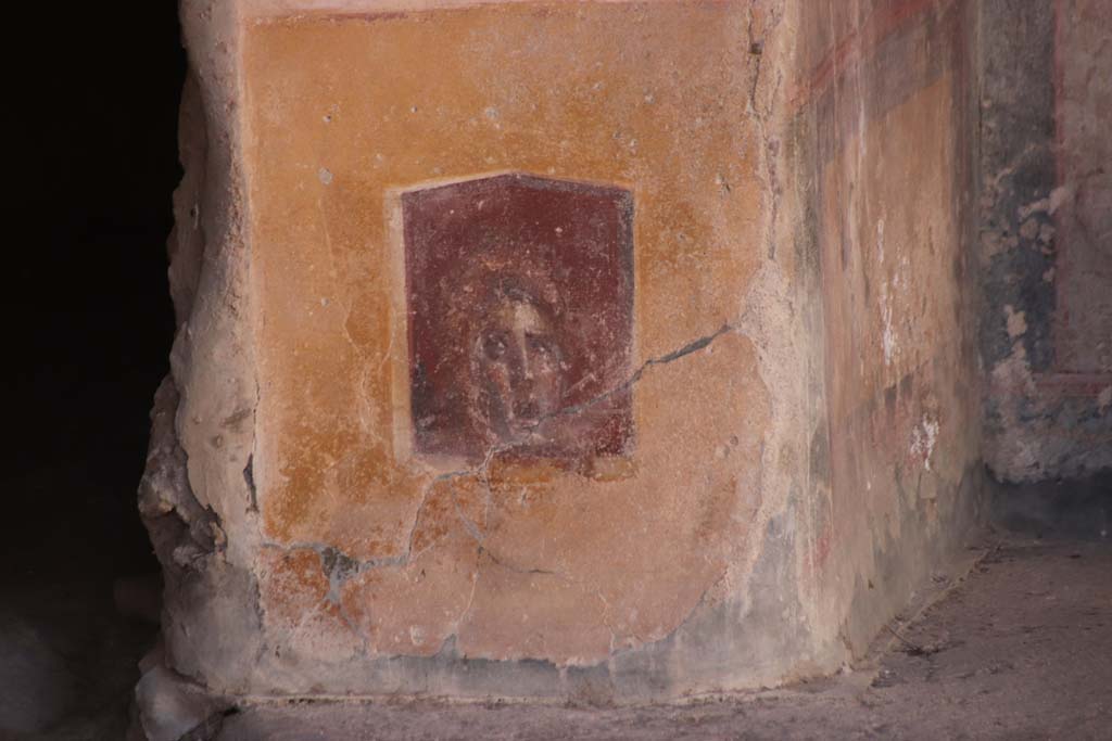 VI.16.15 Pompeii. September 2021. 
Base of painted pilaster with mask on west side of atrium with doorway to room C, on left. Photo courtesy of Klaus Heese.