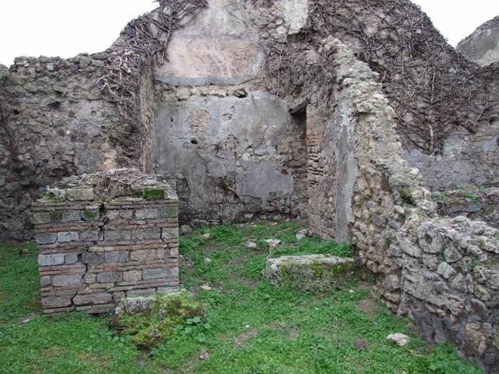 VI.16.18 Pompeii. December 2007. Doorway to rear room in centre, with doorway to rear room on north side. According to NdS, this room contained a limestone boulder that was used to form the first rung of a wooden staircase to the upper floor.  The walls of the room were bare and unpainted and the floor was of opus signinum. In the heights of the north and west walls could be seen the white plaster of the upper room. A small doorway, with large threshold made of pieces of lava, at the left end of the north wall led into a small room.