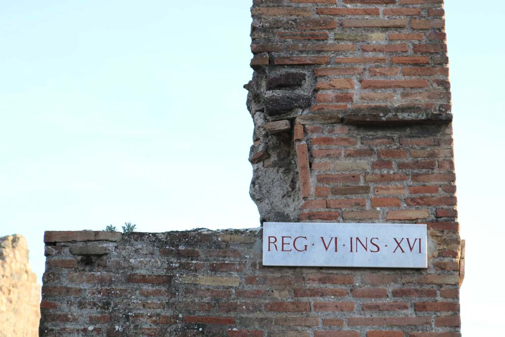 VI.16.23 Pompeii. December 2018. 
Detail of masonry above west pilaster, with insula identification plaque. Photo courtesy of Aude Durand.
