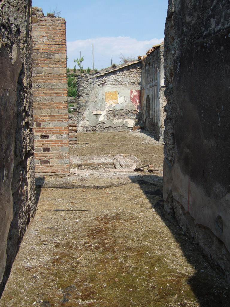VI.16.26 Pompeii. May 2006. Looking east from entrance doorway across fauces A.
According to NdS, this floor was made of opus signinum and sloped upwards from the doorway.
The walls had a high dado of plaster imitating a coarse decoration of marble, and above it was a simple rough plaster.