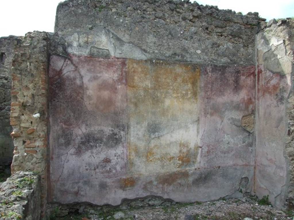 VI.16.27 Pompeii. March 2009. Room L, west wall of tablinum. According to NdS, the tablinum opened in almost its entire width from the atrium on its north side. It had wooden door jambs and maybe even a wooden threshold. The east and west walls preserved their painted decoration as well as a small wall to the left of the wide northern doorway. Each wall showed three large panels, the central yellow, the sides red. These were best preserved on the west wall, where on the yellow central panel was a painting of Atalanta and Meleager. The painting was very poorly preserved. On the left was Atalanta sitting on a chair, on the right was Meleager. Near to him on the left was a dog resting on its back legs, with its head pointing towards its master. Between the dog and Atalanta, the boar, profiled to the right, was on the floor. In the middle of the two red panels of the west wall were small landscapes, without frames, and very faded. The portion of the north wall, to the left of the large doorway to the atrium, offered a red panel with the painting of a mask in the centre. 
On the white frieze, were the usual architecture with suspended objects and arabesques.
The badly preserved dado on a black background was divided into panels by means of reddish bands.  See Notizie degli Scavi, 1908, (p.189)