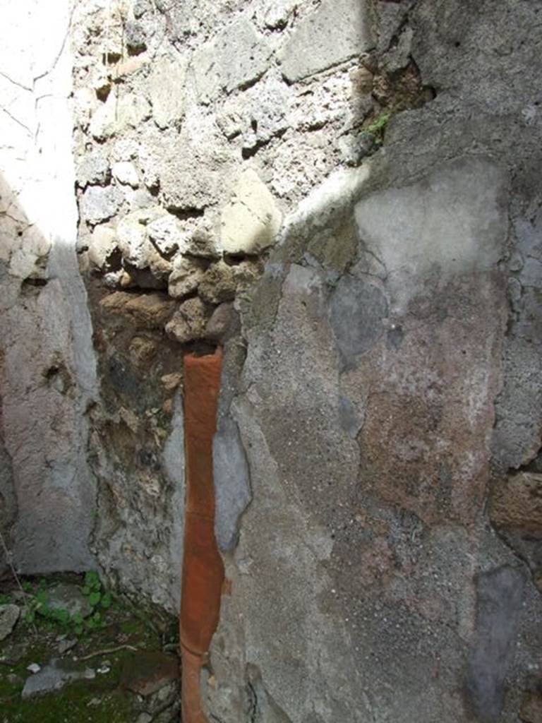 VI.16.28 Pompeii. March 2009. Room G, east wall with down pipe. According to Hobson, there are three down-pipes in this property, two of which may be associated with upper floor latrines. See Hobson, B. 2009. Pompeii, Latrines and Down Pipes. Oxford, Hadrian Books, (p.290, 294-5) According to NdS, in the east wall there was a terracotta down-pipe descending from the upper floor. In the height of the north wall, there were holes for supporting the beams of an upper mezzanine. See Notizie degli Scavi di Antichità, 1908, (p.278)