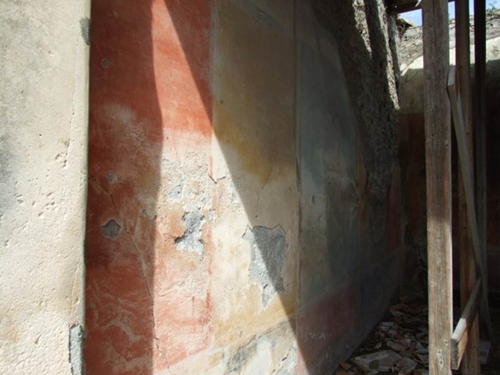 VI.16.28 Pompeii. March 2009. Room F, north wall, showing remains of red, yellow and green panels. According to NdS, The wall was divided into five parts, the central panel was green, the two either side of it were yellow, and the two at the ends were red. The central panel had a painting and was separated from the side panels by two slender columns. The panels of the north wall are divided by simple blackish bands. The upper zone had a white background and preserved a small part of the architectural decoration, and was of the third style. The dado had a red zone in correspondence with the central panel, and two black in correspondence with the four large side panels. See Notizie degli Scavi di Antichità, 1908, (p.273-4). According to PPP, in the centre of this wall was a painting of the Hunt of the Bulls, from which the house was also named. See Bragantini, de Vos, Badoni, 1983. Pitture e Pavimenti di Pompei, Parte 2. Rome: ICCD. (p.368).