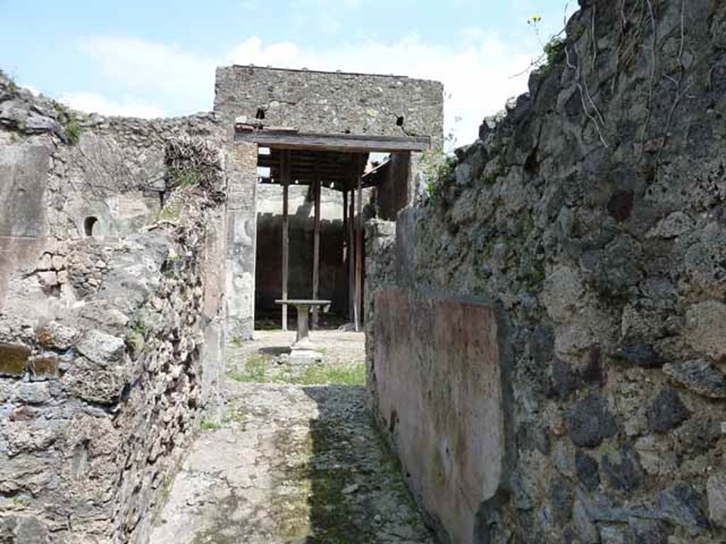 VI.16.28 Pompeii. May 2010. Looking east along fauces A, to atrium C. The floor was made of cocciopesto, in which was buried some pieces of marble without a design. The south wall preserved a high dado on a blackish background, finishing above with a wide red frieze.
Under the frieze was a simple coating of rough white plaster.  Found on the south wall, shown here on the right,  was a graffito MVSQ?N . Above on a coarse white plaster, in rather large letters was COPONII. From this graffito of Coponii, the house gained one of its names. See Notizie degli Scavi di Antichità, 1908, p. 271.