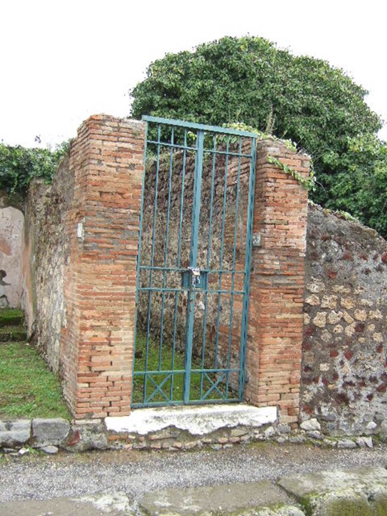 VI.16.35 Pompeii. December 2007. Looking east to entrance doorway. According to NdS, this doorway had brick door-jambs and threshold of travertine. The threshold had holes for the fitting in of the wooden doorframe. The entrance corridor or fauces A, had a floor of Opus signinum with pieces of inlaid marble, and was slightly inclined to the roadway. The walls were coated with a high marble dado with a black background, and inlaid with imitation white marble-like slabs obtained by a white background with red and black fillets. See Notizie degli Scavi, 1908, (p.359-363)