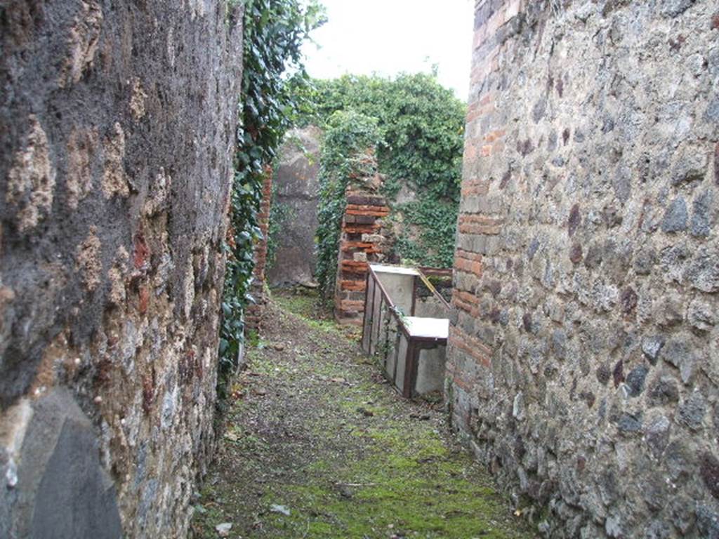 VI.16.35 Pompeii. December 2007.  Looking east from entrance doorway across fauces A towards atrium B, towards small corridor G leading to rear rooms. The rise in the floor of the corridor in the centre of the photo, would be the remains of the steps. On the right, on the east side of the atrium, the small tablinum can be seen.
According to NdS, the small atrium B was bare-walled and the floor was Opus signinum.
At the time of excavation it was noted for its impluvium “a”. This had a very high edge, faced with cocciopesto which had some pieces of encrusted marble in the upper horizontal surface. Running around the inside part was a decoration of  lines of yellow stucco in relief, and in each of the four corners, small palms, also in relief. The background consisted of a large disc of white marble and around it pieces of marble of various colours. The walls of the atrium were decorated with simple white plaster, the floor was of cocciopesto and formed a continuation with the floor of the fauces. At the extreme right of the northern wall of the atrium were three steps in masonry, plaster coated. Following these, a staircase also in masonry recessed between rooms E and H, leading to the upper floor.
On the east side of atrium B opened the full-width tablinum C. It had bare walls and its floor was Opus signinum, similar to the atrium and fauces. The left jamb would have been of wood, and it corresponded on the right with a brick pilaster. In the east wall of the tablinum would have been a wide window which would have had a wooden window-sill. This window gave light into room F, which was all faced with cocciopesto.
On the west side of the atrium was a doorway into room D, this doorway had wooden jambs and a threshold of masonry forming a step. The room did not provide anything notable, it had cocciopesto flooring and walls with a white background divided by red lines into large panels. In the west wall was a window overlooking Vicolo dei Vettii. 
On the north side of the atrium was a doorway which was to the left of the aforementioned stairs, this led into room E. The doorway had wooden jambs and it seemed also, a threshold of wood. The rectangular room had a floor of cocciopesto and walls with a high plinth of brick plaster. In the south wall a small window protruded into the atrium.
Room G was a rather narrow corridor, whose entrance from the atrium had a wooden threshold. In its eastern half it was only separated from room F by a low wall. In the corner of this low wall and the east wall, the mouth of a tank made of terracotta, covered in robust masonry was found, “b”.
Room H opened from the north side of corridor G, its doorway had a lava threshold and originally would have had wooden door-jambs. This room did not offer any other decoration other than the usual brick plaster plinth on the walls, and floor of cocciopesto. A pile of lime was in the north-west corner.  To the right of the doorway in the south wall, was a window into corridor G, and in the west wall was a room under the stairs. This room was transformed into an apotheca, as proved by the holes for the shelving supports. See Notizie degli Scavi, 1908, (p.359-363)