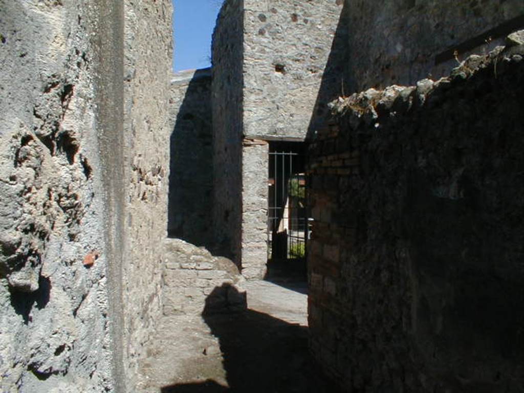 VI.16.38 Pompeii. September 2004. Looking east into corridor U from rear entrance. Looking east to steps to upper floor, room V, and doorway to room F, north-west portico.