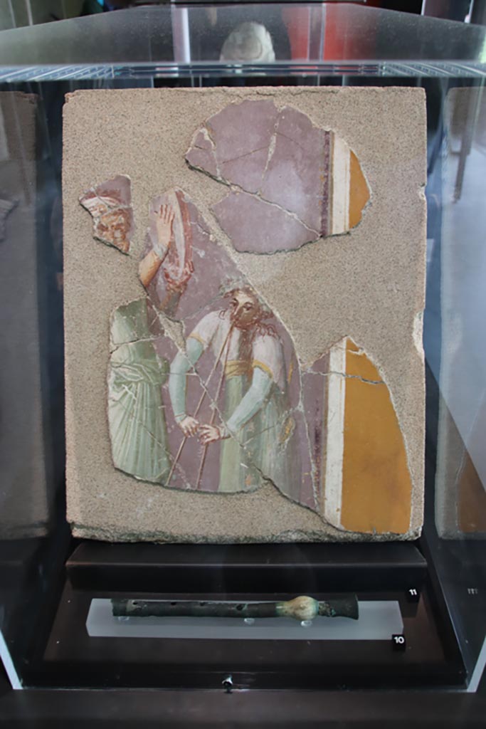 Insula Occidentalis, Pompeii. May 2024. Photo courtesy of Klaus Heese.
No.11, fresco with travelling musicians. (Ist century AD). (Affresco con musici ambulanti (I sec. d.C).
On display in exhibition in Palaestra entitled – “L’altra Pompei, vite comuni all’ombra del Vesuvio”.
No.10 below, flute made of bone and sheet bronze. (Ist century AD), from I.12.6.