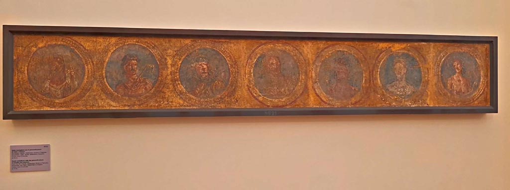 Pompeii Insula Occidentalis. October 2023. Seven medallions with personifications of months and seasons. 
Now in Naples Archaeological Museum. Inventory number 9521. Photo courtesy of Giuseppe Ciaramella. 
On display in “L’altra MANN” exhibition, October 2023, at Naples Archaeological Museum.
Pastiche of calendar of the months made from 4 separate fragments making 7 medallions, found beneath the Cuomo property. 
From the left the pieces are
1: Genius Augusti, a youth in yellow cloak holding a rake, elderly person with yellow clothes and covered head.
2: Head of Diana with crescent moon.
3: Giove with long sceptre and Venere.
4: Naked youth with crown of vine leaves and swollen mantle of seasonal fruits.
According to Grasso these represent:
Agosto, Settembre, Gennaio, Febbraio, Novembre, Luglio, Aprile e Settembre.
(August, September, January or February, November, July, April and September.)
The fragments were detached from a wall in Pompeii in May 1760 and would have been part of a medallion frieze with blue backgrounds, in a room with walls painted in yellow ochre.
The picture frame contains four fragments which make up the seven medallions.
See Bragantini, I & Sampaolo, V (eds). 2009. La Pittura Pompeiana, (Electa), (p. 530-1)
According to Pagano and Prisciandaro, this was found 26th April - 2nd May 1760, in the same room as 9518, 9519, and 9520. (PAH,1,106)
See Pagano, M. and Prisciandaro, R., 2006. Studio sulle provenienze degli oggetti rinvenuti negli scavi borbonici del regno di Napoli. Naples: Nicola Longobardi. (p.33)