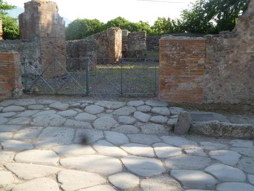 VI.17.1 Pompeii. May 2011. Looking west towards ramp leading to entrance.
According to Fiorelli, the first entrance commencing from the Herculaneum Gate was an inn with annexed bar. Recognisable by the lowered ramp for the access of the wagons and animals, by the wide doorway introducing into an area, that had on the right the kitchen, the shelter for the vehicles, the stable, the latrine, and a large room from which one went down to the cellar and passed in a space enclosed between the city gate and the city wall, used for the rubbish, where various animal bones were found. On the left and in front of it were dormitories, and maybe even dining areas. 
See Pappalardo, U., 2001. La Descrizione di Pompei per Giuseppe Fiorelli (1875). Napoli: Massa Editore. (p.158)
See PAH, 1,1,236 (30th December 1769) with addendum 154, and PAH 1,1,238 (5th May 1770), with addendum 155.
