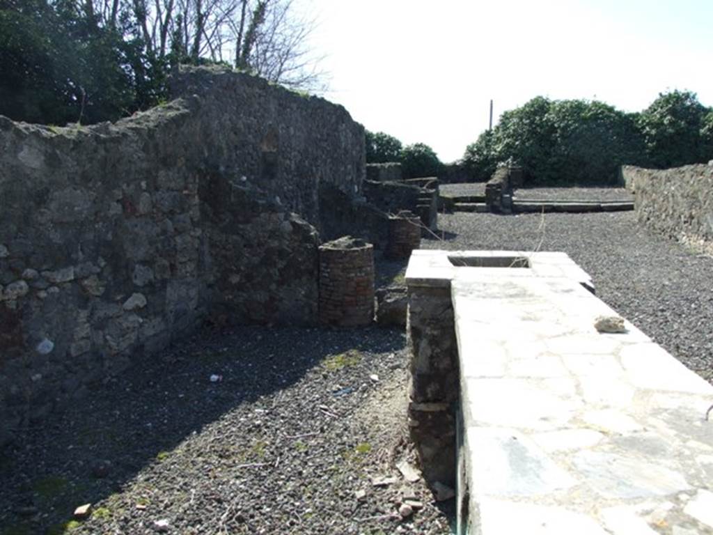 VI.17.4 Pompeii. March 2009. Looking west along marble counter and hearth to rear. In the upper right can be seen the rear room with the lava threshold, the middle room described by Fiorelli as one of three large rooms, at the rear. According to Fiorelli, a corridor led to the interior and to its side was a cupboard, a triclinium, and two rooms, and then (?on the other side) was another triclinium and a cubiculum. At the rear were three large rooms, and from one of these was the passageway towards the hospitium (VI.17.1).
See Pappalardo, U., 2001. La Descrizione di Pompei per Giuseppe Fiorelli (1875). Napoli: Massa Editore. (p.138)