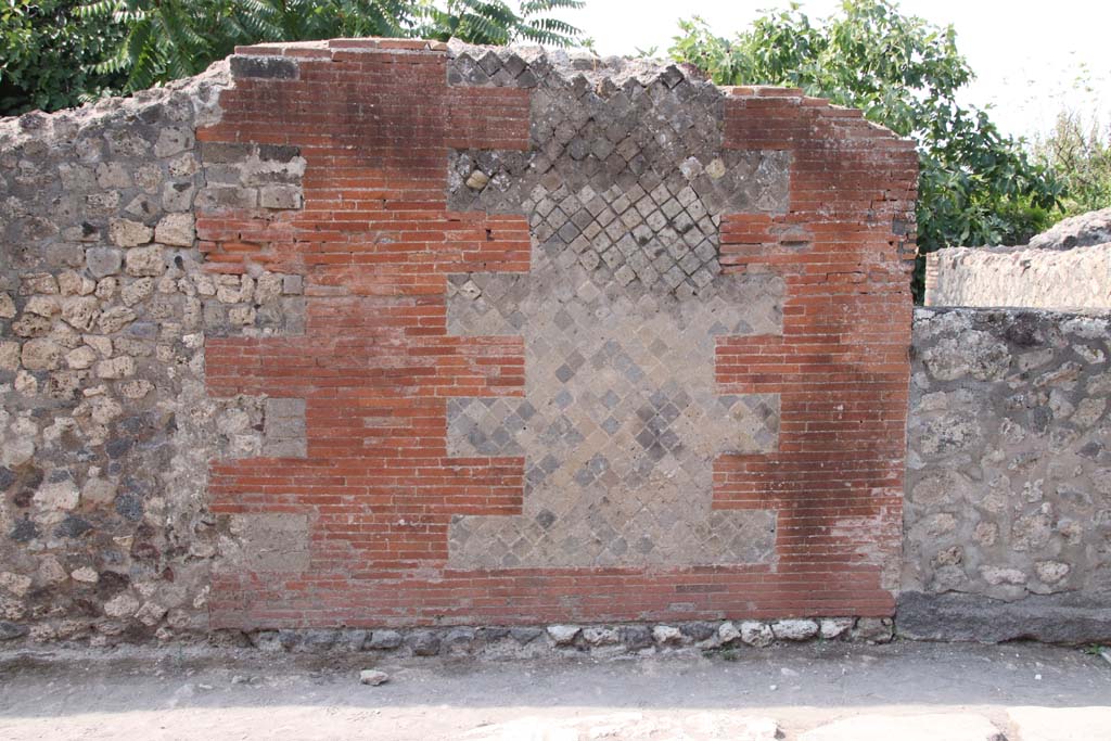 VI.17.9, on right, Pompeii. September 2021. Street façade on left (south) of blocked entrance doorway. Photo courtesy of Klaus Heese.