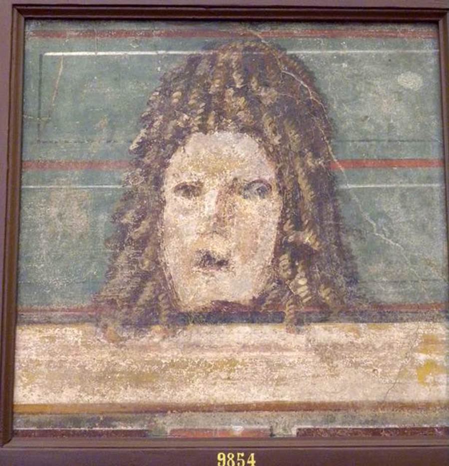 VI.17.9-10 Pompeii. Found 20-29 October 1763 or 2nd July 1763
Mask, found at the same time as the other two, but the colour was faded and the face was ruined by a pointed instrument. 
Now in Naples Archaeological Museum. Inventory number 9854.