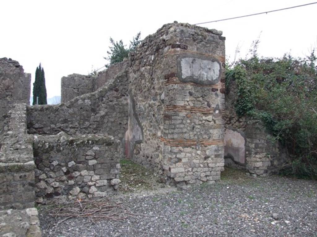 VI.17.10 Pompeii. December 2007. South side of atrium from entrance. Looking towards doorways of two of the three cubicula.
According to Allroggen-Bedel – In the room next to the Ala, right from room No.10 (doorway on right of photo), there is no depression for the bed.  In the room on the left (from room No.10), next to the steps, you can still see the remains of a red zoccolo, and a yellow middle zone.  The remains of these decorations agree with La Vega description of room No.13 –
“From the 9th to the 18th December, we excavated the indicated small room. The floor was of slabs of crushed brick (lastrico di mattoni pesto).  In the plaster the zoccolo has the red background: the bottom of the panels that lay above the zoccolo was yellow with some birds in the middle; the bands that divided these squares were red, embellished with grotesque architecture, which still adorned the decoration above that had a white background.”