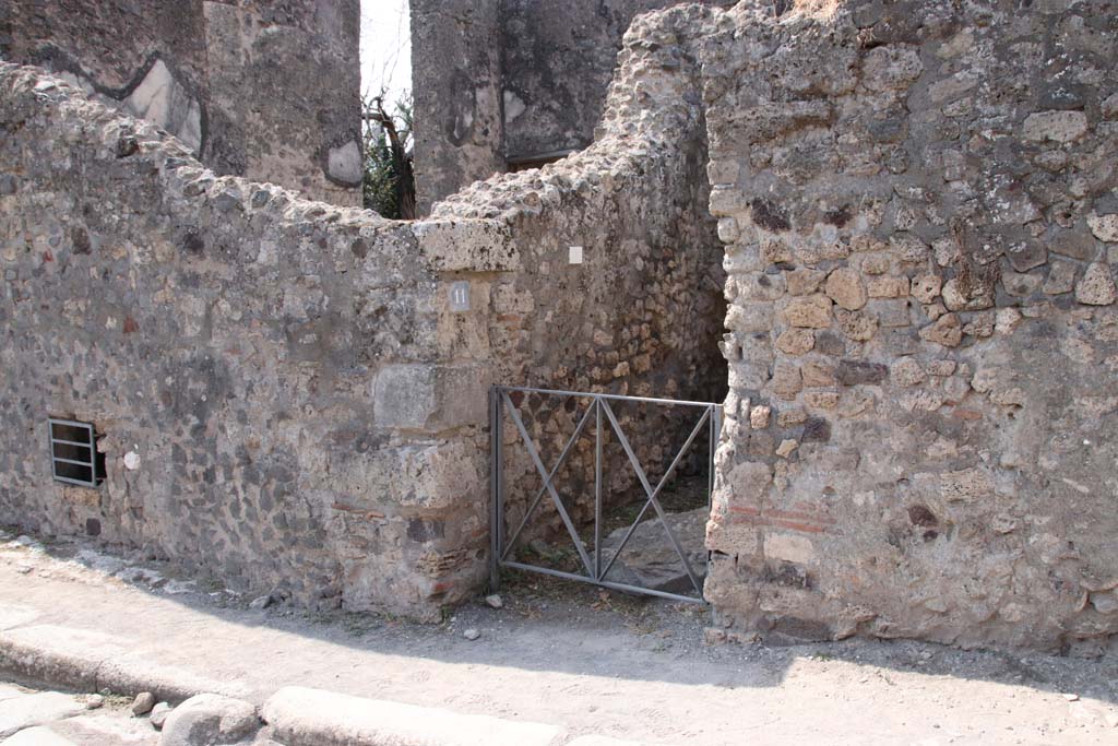 VI.17.11 Pompeii. September 2021. Looking south-west towards entrance on Via Consolare. Photo courtesy of Klaus Heese.
On the left of the entrance would be the underground area of VI.17.12, with the triclinium of VI.17.13, above it.
See comment in VI.17.13, repeated below -
According to Allroggen-Bedel, she could not locate rooms 11 and 12 of VI.17.10, but, she wrote -
“However two rooms in the next door house (VI.17.12-13) meet the description of rooms nos. 11 and 12.
La Vega said that in the space described as no.12, he had discovered a “sotterraneo” (underground room/cellar, etc). 
The characteristics of the rooms– bed recess and sotterraneo, were both to be found next to the cellar stairs in VI.17.12.
The room described as no.11 is probably identical with the room next door (VI.17.13), where the remains of the yellow background central zone decorations  were preserved.”
See Allroggen-Bedel - Die malereien aus dem Haus Insula Occidentalis 10, in Cronache Pompeiane II, 1976 (p.144-183).