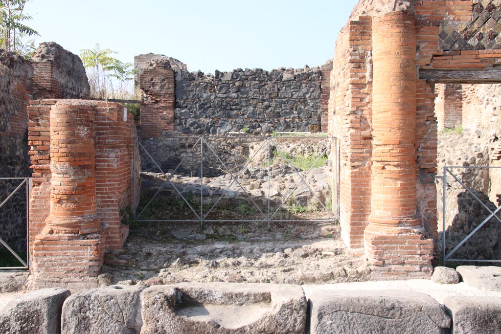 VI.17.36 Pompeii. October 2023. 
Looking west past step cut in kerb to entrance doorway with a brick half round column on each side. Photo courtesy of Klaus Heese.