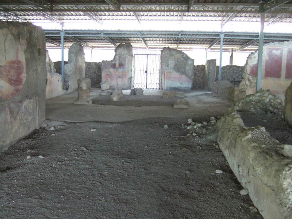 VI.17.41 Pompeii. May 2006. Looking east from rear of tablinum towards atrium and entrance.
According to PPM, this room has been very badly preserved, it was damaged during the Bourbon excavations when the south wall of the neighbouring room was cut away, and was possibly deprived of its mosaic floor at that time.
On the north wall, the only wall that retains any decoration, the zoccolo was red and in it, in the centre of the wall a female figure can be seen.
In the middle area of the wall, resting his right foot on the base of a podium was a huge figure and nearby the bow of a ship. 
The zoccolo appeared to be more sunken into the wall than the rest of the wall, and with its sharp break from the painting of the middle area, may have been of an earlier wall decoration.