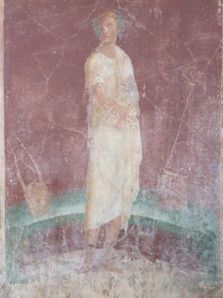 VI.17.41 Pompeii. October 2010. east wall of exedra 18 on north side of cubiculum 17. 
Detail of painting of robed figure with instruments. Photo courtesy of Gaby Große.