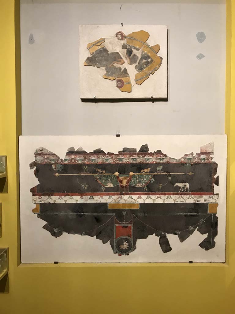 VI.17.42 Pompeii. April 2019. Fragments of III Style decoration photographed on display in Antiquarium. 
These fragments were found in 1983, together with numerous others, in the garden area.
They were from a room damaged following the 62AD earthquake
Top: Oval fragment of Satyr and Maenad from upper zone of a wall.
Lower: Fragment of predella on black background (PAP inventory number 86078)
Photo courtesy of Rick Bauer.
See Aoyagi M. and Pappalardo U. et al, 2006. Pompei (Regiones VI-VII) Insula Occidentalis, I. Napoli: Valtrend. (p.222 and 244, and 248).